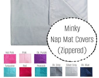 May include: A gray minky nap mat cover with a zipper. The image shows a variety of colors available, including hot pink, pink, dark purple, turquoise, red, peacock, dark gray, silver gray, and dark blue.