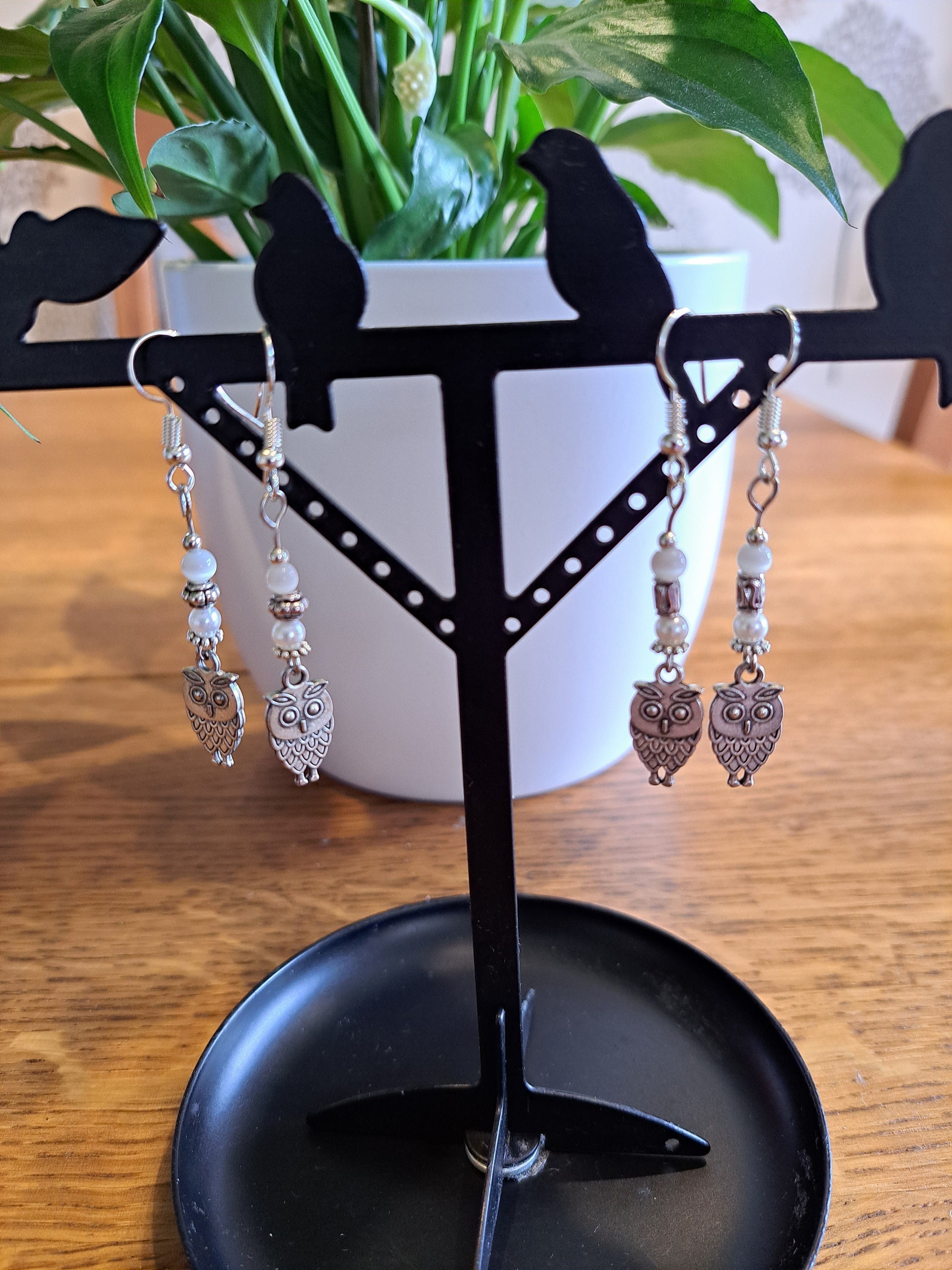 Silver coloured drop earrings featuring owls