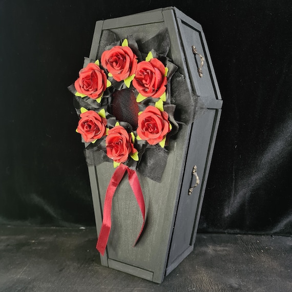 A miniature handmade wooden coffin with its own stretcher stand — equal parts gothic trinket box and stunning display prop.