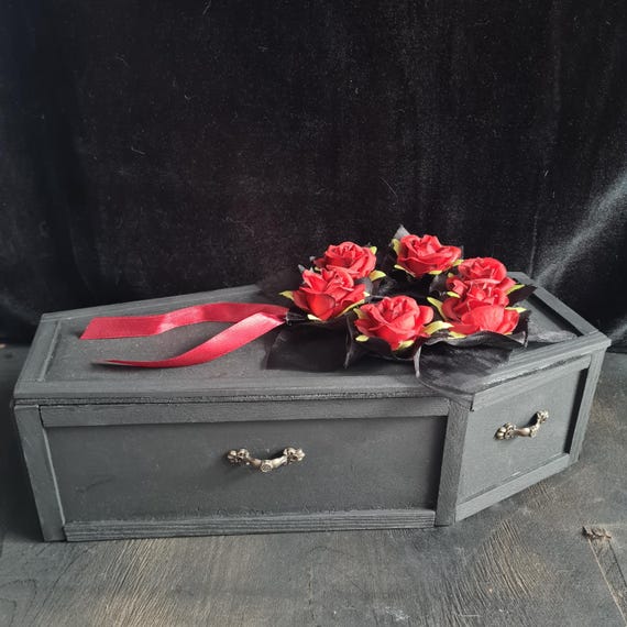 A miniature handmade wooden coffin with its own stretcher stand — equal parts gothic trinket box and stunning display prop.