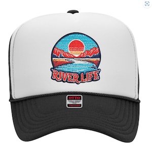 May include: A trucker hat with a white front panel and a black brim. The hat features a circular patch with a landscape design of a river, mountains, and a setting sun, with the words "RIVER LIFE". The hat has a black mesh back.