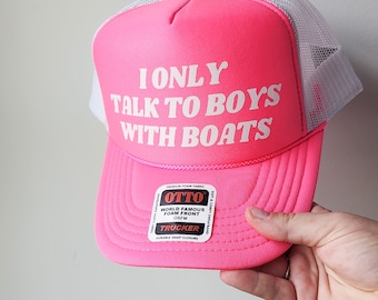 May include: Pink trucker hat with a white mesh back. The front of the hat has white text that reads "I ONLY TALK TO BOYS WITH BOATS". The hat has a black and red label that reads "OTTO WORLD FAMOUS FOAM FRONT OSFM TRUCKER DURABLE SNAP CLOSURE".