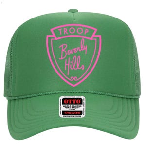 May include: A green trucker hat with a pink shield-shaped graphic that reads "TROOP Beverly Hills." The hat has a foam front and a mesh back. The hat also has a tag that says "OTTO" and "TRUCKER."