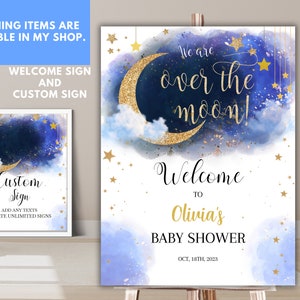 May include: A blue and gold baby shower welcome sign with a crescent moon and stars. The text reads "We are over the moon! Welcome to Olivia's Baby Shower Oct. 18th, 2023".