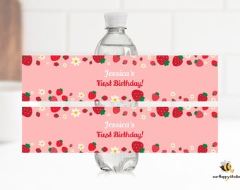 Puede incluir: Una botella de agua con una etiqueta rosa con fresas rojas y margaritas blancas. La etiqueta dice "Jessica's First Birthday!" en escritura roja. El diseño incluye un borde de fresas y margaritas.