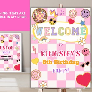 Pu&ograve; includere: Un cartello di benvenuto a scacchi rosa e bianco con una palla da discoteca, facce sorridenti, simboli di pace e arcobaleni. Il cartello dice "Benvenuti alla festa di compleanno di Kingsley!"