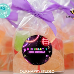 以下が含まれることがあります： カラフルなキャンディーで満たされたパーティーのお土産袋。ネオンをテーマにしたバースデーシールが貼られており、「Kingsley's 12th Birthday」と書かれています。