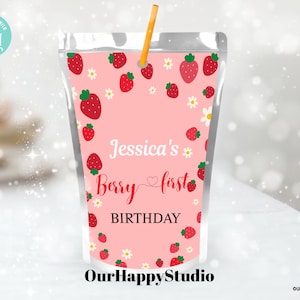 May include: Pink and white juice box with a straw, featuring a strawberry pattern and the text "Jessica's Berry first BIRTHDAY".