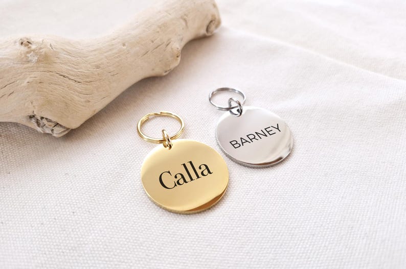 Peut inclure: Deux m&eacute;dailles d'identification rondes en m&eacute;tal pour animaux de compagnie avec des anneaux. La m&eacute;daille dor&eacute;e indique "Calla" et la m&eacute;daille argent&eacute;e indique "Barney".