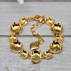 May include: Gold bracelet with a heart charm and round settings for stones. The bracelet is made of metal and has a lobster claw clasp.