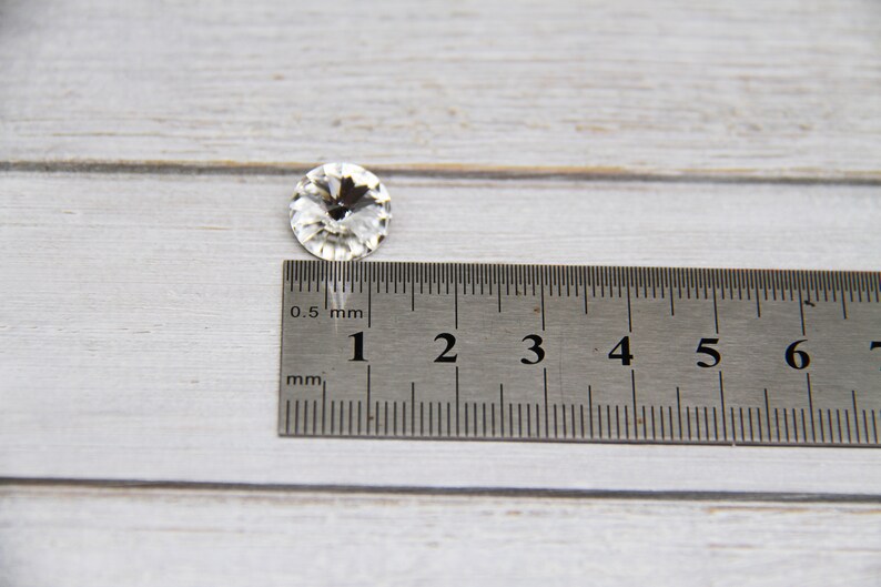 K&ouml;nnte beinhalten: Ein klarer Kristall-Strass mit einem Durchmesser von 1 cm, neben einem Lineal.