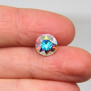 May include: A round iridescent blue gemstone with a faceted design.