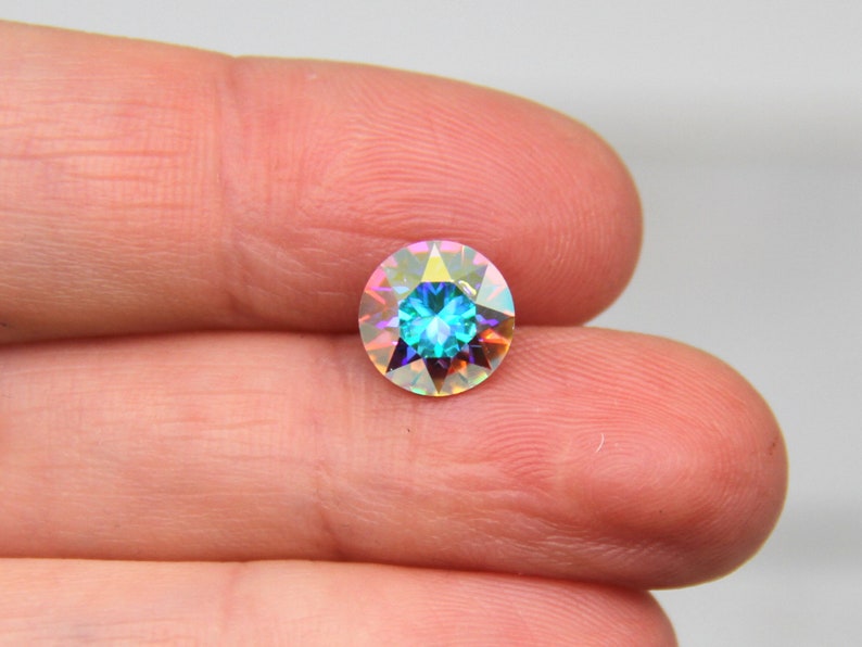 May include: A round iridescent blue gemstone with a faceted design.