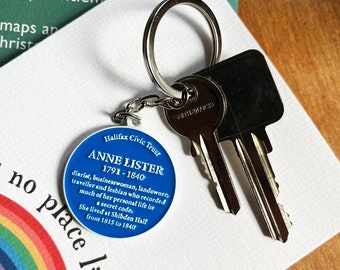 May include: A blue and white circular keychain with the text "Halifax Civic Trust" and "Anne Lister 1791-1840" and a description of her life. The keychain is attached to a silver key ring and a silver key.