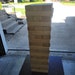May include: A tall, freestanding tower game made of many light-brown, unfinished wooden blocks.  The blocks are stacked neatly, creating a rectangular prism shape. The game is a classic stacking game, perfect for indoor or outdoor play.  It's a great choice for family game nights or parties.