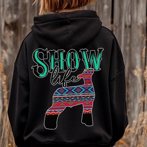 May include: Black hooded sweatshirt with the text "SHOW life" and a colorful patterned sheep silhouette on the back.
