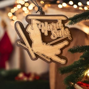 May include: Wooden Christmas ornament shaped like a skier with the words "Yard Sale" written on it.