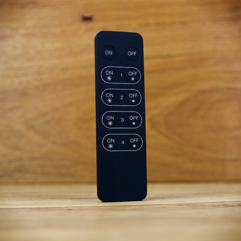 May include: Black remote control with four buttons labeled "ON" and "OFF" with a number from 1 to 4. Each button has a small asterisk symbol.