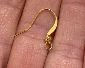 May include: Gold earring hook with a small ball at the end.