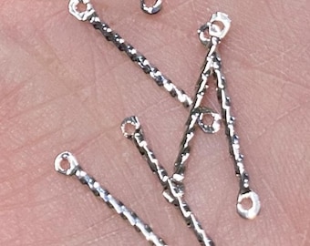 Puede incluir: Primer plano de seis anillos de salto plateados con un diseño retorcido. Los anillos de salto miden aproximadamente 2,5 cm de largo y tienen un pequeño bucle en cada extremo.