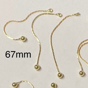 May include: A group of ten gold chain extenders with small round balls at the ends. Each extender measures 67mm in length.