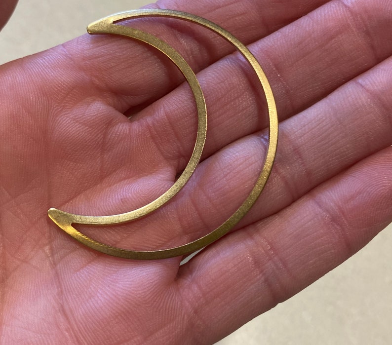 May include: A gold crescent moon shaped metal pendant.