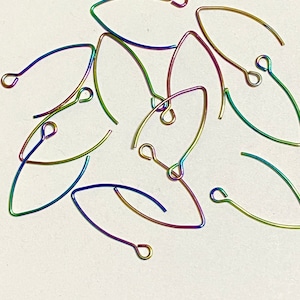 May include: A group of rainbow colored earring hooks. The hooks are made of metal and have a teardrop shape.