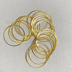 May include: A stack of gold-colored metal rings, likely for jewelry making or crafting.