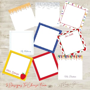 May include: A collection of nine square note pads featuring various school-themed designs including yellow pencils, paper clips, colorful crayons, alphabet letters, red apples, lined paper, and rulers, with some pads personalized with names like Mrs. Smith.