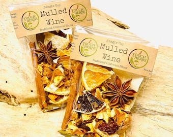 May include: Two sachets of mulled wine spice blend, containing cinnamon sticks, star anise, and dried orange slices. Each sachet is labelled "Mulled Wine" and "Touch Herbs". The blend is a traditional Glühwein blend.