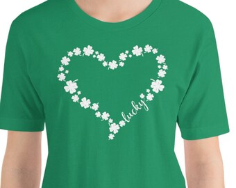 May include: Green short-sleeved t-shirt with a white heart design made of shamrocks. The word "lucky" is inside the heart.