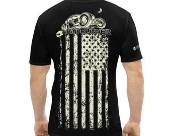 May include: Black t-shirt featuring a distressed American flag design with the text "shineRUNNER" and a vintage car graphic. The shirt is short-sleeved and has a crew neck. The design is printed on the back of the shirt.