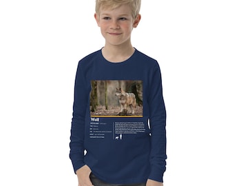 May include: A navy blue long-sleeve t-shirt for kids features a wolf in a forest setting. The shirt has a white text box with the word "Wolf" and information about the animal.