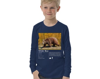 May include: A navy blue long-sleeve t-shirt with a graphic of a grizzly bear in a forest setting. The shirt has the words "Grizzly Bear" and information about the bear printed on the front.