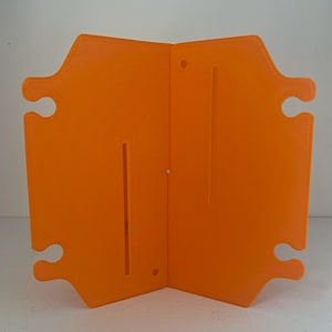 May include: Orange plastic divider with two slots and four holes. The divider is folded in half.