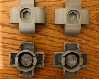 May include: Four gray plastic connectors with a hexagonal hole in the center. Two connectors have a raised lip around the hole, while the other two have a flat surface.