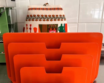 Op de afbeelding: Een feloranje metalen bureau-organizer met vier trapsgewijze vakken en inkepingen voor gemakkelijke toegang tot documenten. De structuur is gemaakt van massief metaal met een gladde afwerking en een getrapt ontwerp voor opslag.