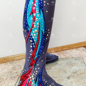 Op de afbeelding: Grijze danstights met een kleurrijk ontwerp met blauwe, turquoise en roze veren. Het ontwerp is versierd met strass.