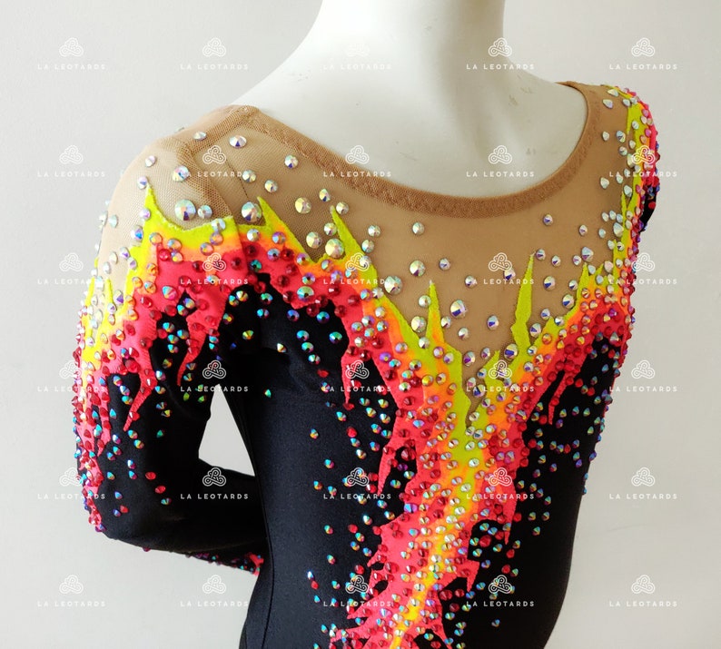 Puede incluir: Leotardo negro de manga larga y cuello redondo. El leotardo est&aacute; decorado con brillantes de colores en forma de llama.