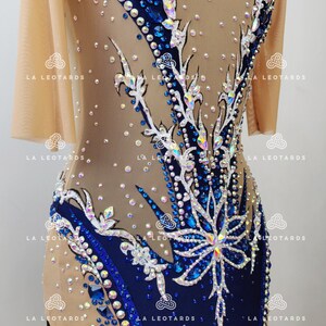 Pu&ograve; includere: Un body blu e nudo con un design floreale e strass. Il body ha maniche corte e una scollatura rotonda.