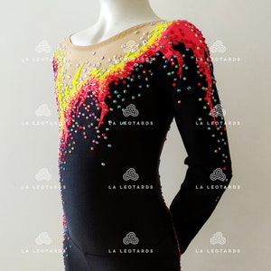 Puede incluir: Leotardo negro de manga larga con un dise&ntilde;o colorido con detalles en amarillo, rosa y rojo. El leotardo est&aacute; cubierto de pedrer&iacute;a iridiscente.