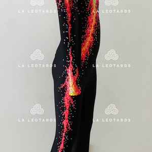 Puede incluir: Leotardo negro con un dise&ntilde;o de llamas rojas y amarillas y pedrer&iacute;a. El leotardo tiene mangas largas y un escote alto.