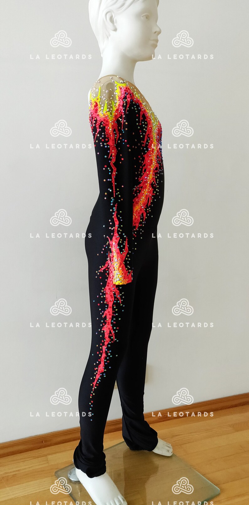 Puede incluir: Leotardo negro con un dise&ntilde;o de llamas rojas y amarillas y pedrer&iacute;a. El leotardo tiene mangas largas y un escote alto.