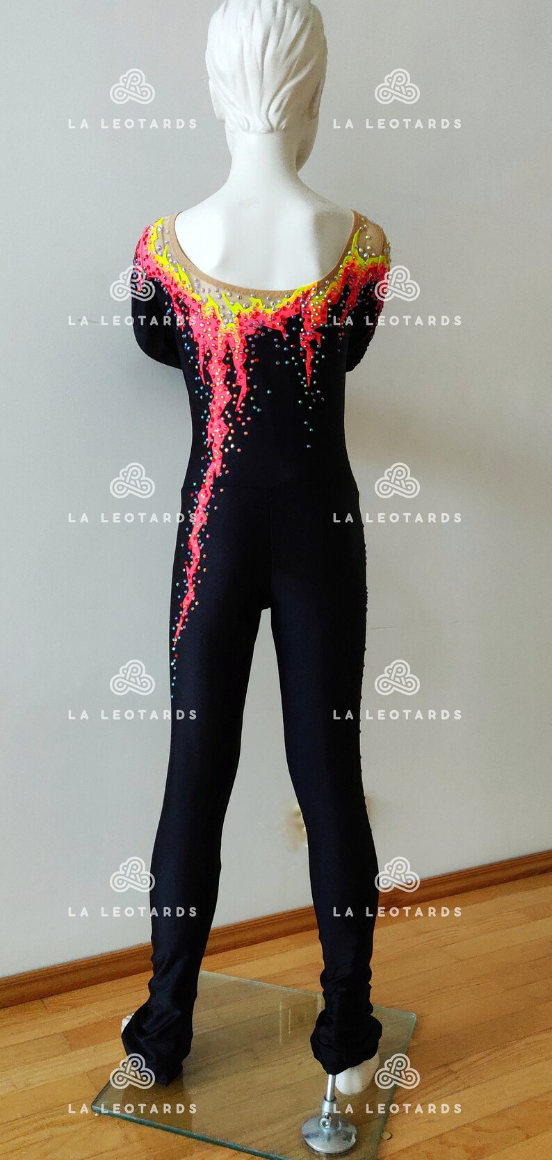 Puede incluir: Leotardo negro con un dise&ntilde;o colorido con detalles en amarillo, rosa y negro. El leotardo est&aacute; decorado con pedrer&iacute;a.