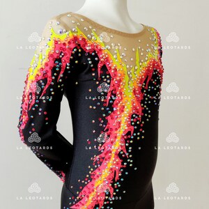 Puede incluir: Leotardo negro de manga larga con un dise&ntilde;o de llama colorido. El dise&ntilde;o presenta pedrer&iacute;a roja, amarilla y rosa.