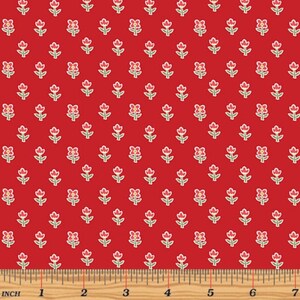 May include: Red fabric with a repeating pattern of small white flowers with red centers. The fabric is measured with a ruler in inches.