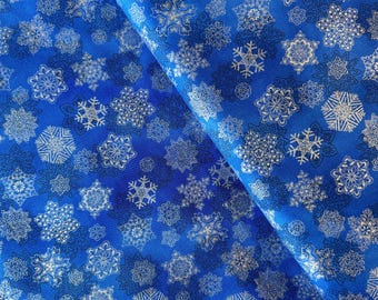 May include: Blue fabric with a white snowflake pattern. The fabric is folded in half, showing the pattern on both sides.