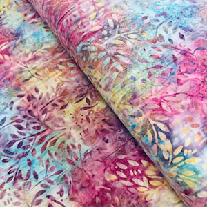 May include: A roll of fabric displaying a colourful, watercolour-style design. The pattern incorporates pink, purple, blue, and yellow tones, with a leaf-like design. The fabric has a soft appearance and a subtle sheen, indicating a high-quality material.