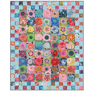 Op de afbeelding: Een kleurrijke quilt met een patchwork-ontwerp van bloemen vierkanten. Elke vierkant toont een andere bloem in heldere tinten roze, rood, blauw, geel en groen. De quilt is omrand met een lichtblauw en zwart geblokt patroon.