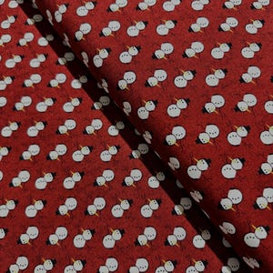 May include: Red fabric with a repeating pattern of white snowmen. Each snowman is made up of two snowballs with a black top hat and a yellow carrot nose.